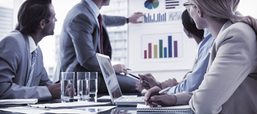 Foto de pessoas em reuni�o conferindo gr�ficos.