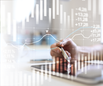 Duas imagens est�o sobrescitas. A inferior � uma foto de m�o utilizando um tablet sobre a mesa. Em primeiro plano aparece a imagem de gr�ficos gerados eletronicamente.